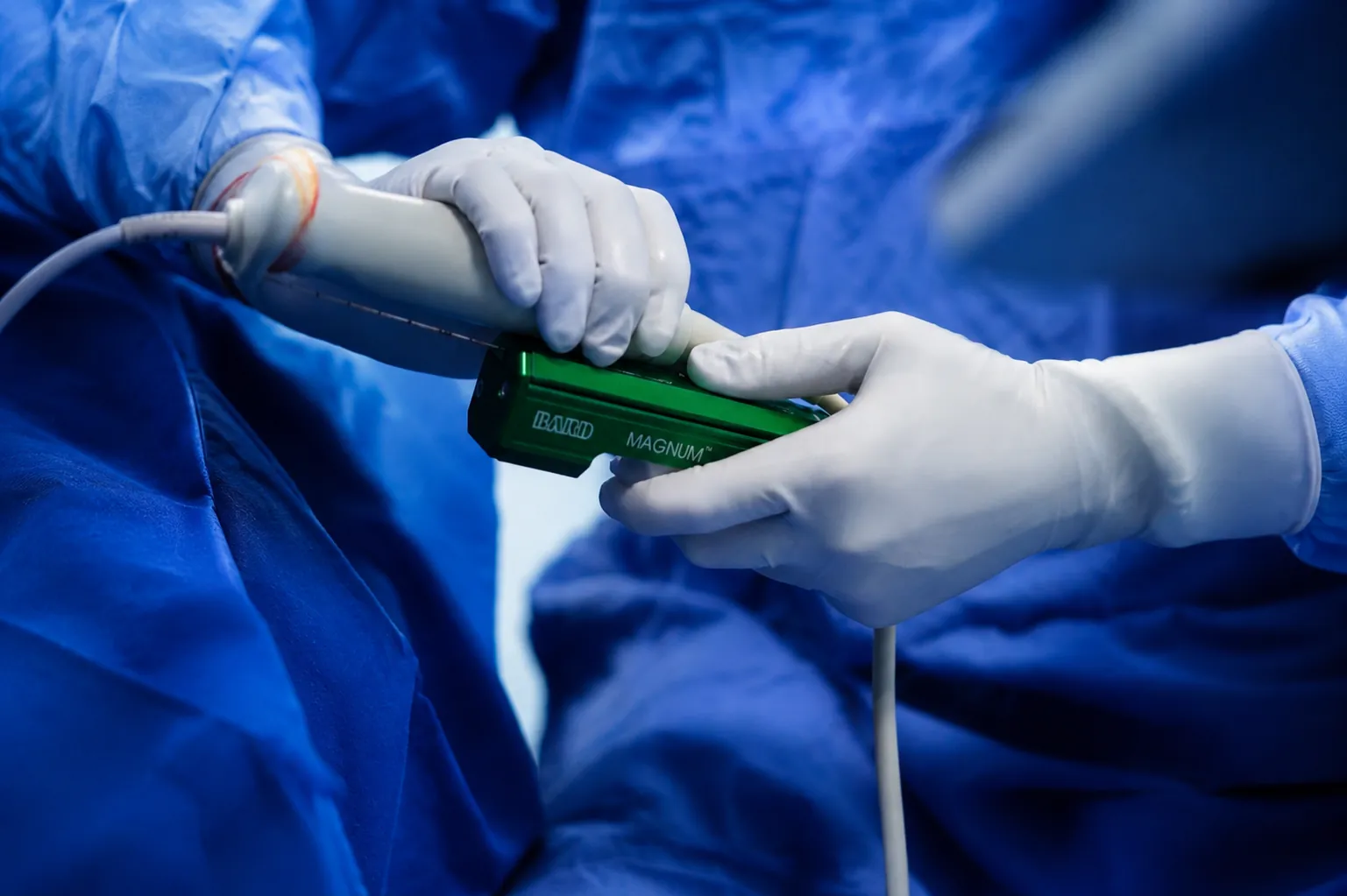 Manos del médico sosteniendo la pistola de biopsia con la sonda de ultrasonido